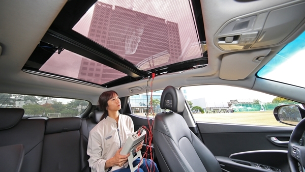현대기아차 연구원이 투광이 가능한 2세대 솔라루프가 설치된 자동차 안에서 효율을 측정하고 있다. ⓒ 현대자동차
