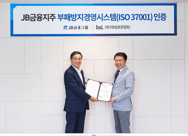 JB금융그룹 김기홍 회장(왼쪽)이 BSI 코리아 송경수 총괄 책임으로부터 지난 30일 서울 여의도 JB빌딩에서 'ISO 37001' 인증서를 수여받고 있다. ⓒJB금융그룹