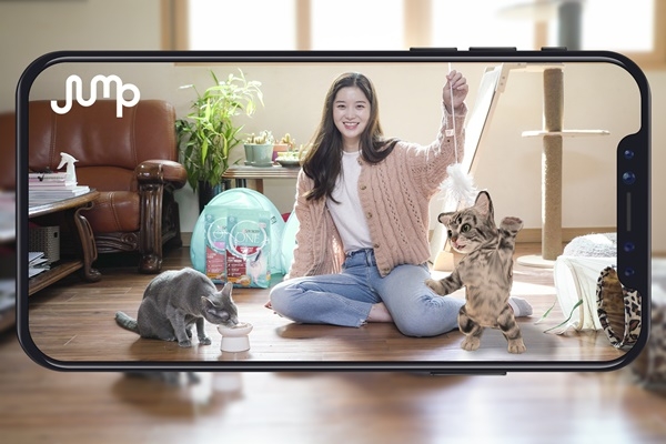 SK텔레콤 홍보모델이 스마트폰으로 실제 고양이와 AR 동물을 함께 촬영하고 있다. ⓒSK텔레콤