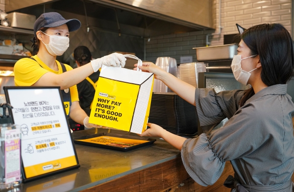 서울 성동구 성수동 노브랜드 버거 매장에서 고객이 주문한 음식을 테이크 아웃하고 있다. 신세계푸드