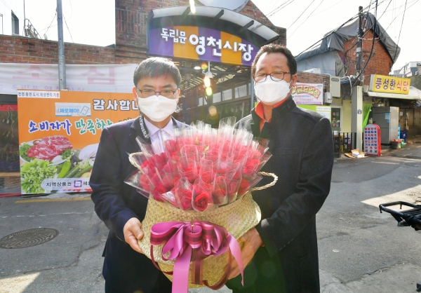 농협은행 WM사업부 신용인 부장(사진 왼쪽)이 박종복 영천시장 상가번영회장에게 꽃을 전달 후 기념촬영을 하고 있다. ⓒ농협은행
