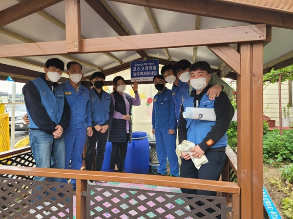 포스코케미칼 마그네시아 공장직원들과 지역아동센터장이 직접 지은 원두막에서 기념사진을 촬영하고 있다.ⓒ포스코케미