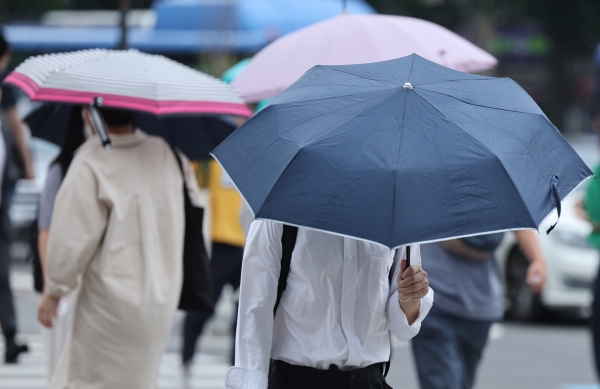 가벼운 소나기가 내린 지난 4일 오후 서울 종로구 광화문네거리에서 우산을 쓴 시민들이 이동하고 있다. ⓒ연합뉴스
