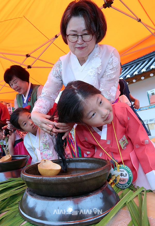 전통 명절 단오를 하루 앞둔 21일 서울 강남구 못골한옥어린이도서관에서 열린 2023 단오한마당에서 어린이들이 창포물 머리감기 체험을 하고 있다. 
