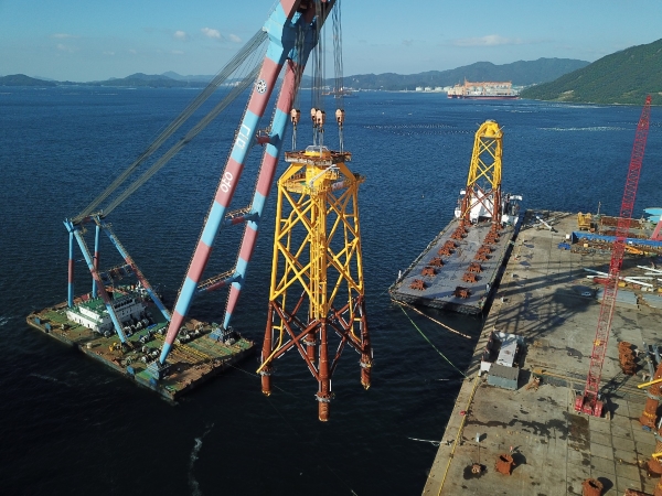 SK에코플랜트 자회사 SK오션플랜트가 수출을 위해 해상풍력 하부구조물을 배로 옮기고 있다. ⓒSK에코플랜트