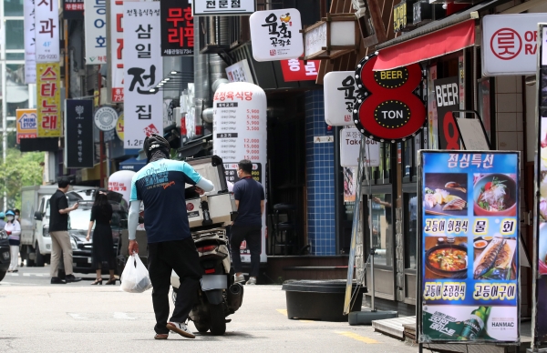 수도권 사회적 거리두기 4단계가 시행된 12일 오후 한 배달 오토바이 기사가 점심 배달을 하고 있다. 연합뉴스