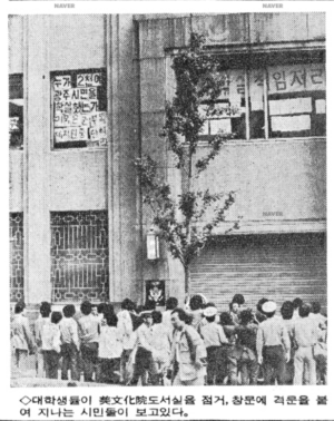 1985년 5월 24일 자 매일경제 기사. 대학생들이 미문화원 도서실을 점거, 창문에 격문을 붙여 지나는 시민들이 보고 있다. ⓒ 네이버 뉴스라이브러리 캡처본